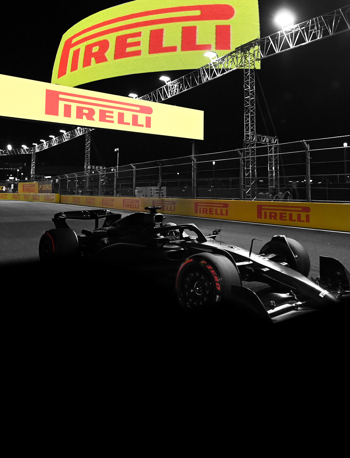 Pirelli logo signs and race car at night at racetrack
