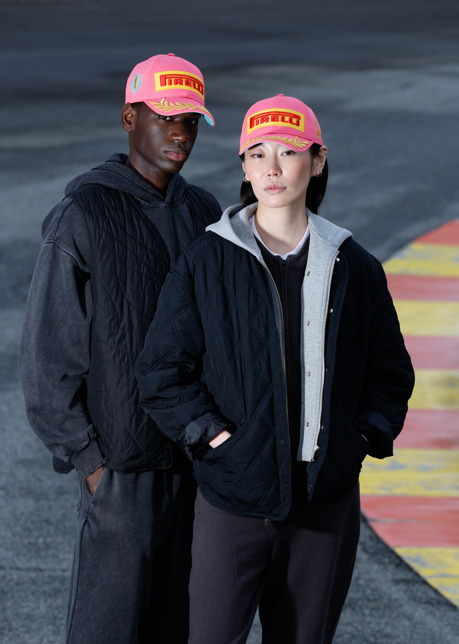 man and woman in pink Pirelli Podium Cap at racetrack
