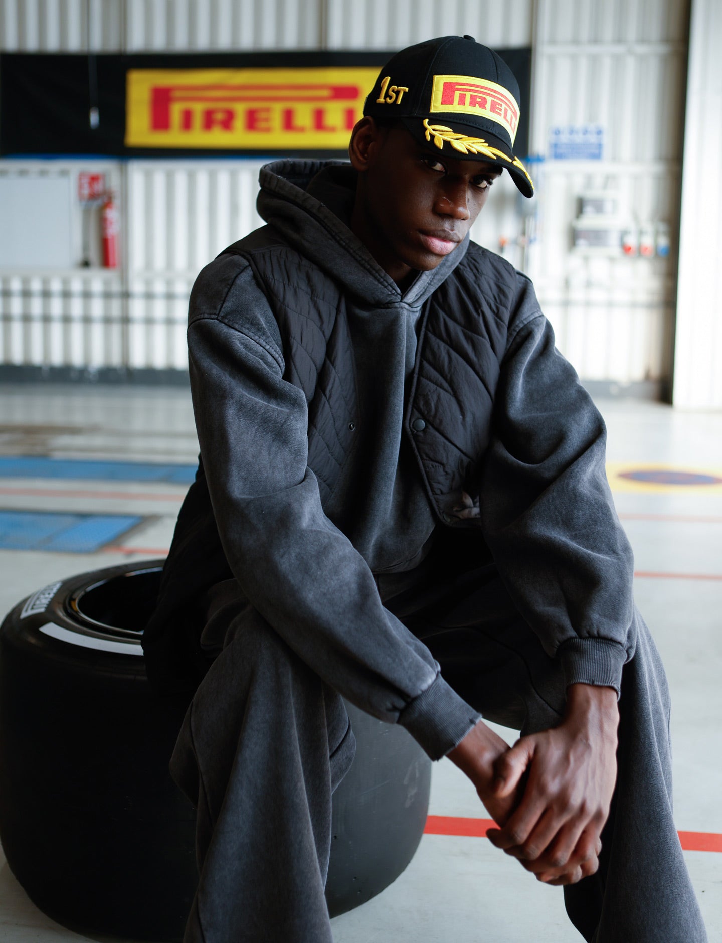 Pirelli black cap - man sitting on tyre